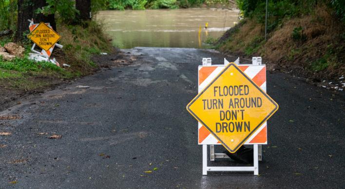 Road Closure and Flash Flooding destroys bridge and leaves a low water crossing deadly and dangerous - turn around don't drown sign in road.