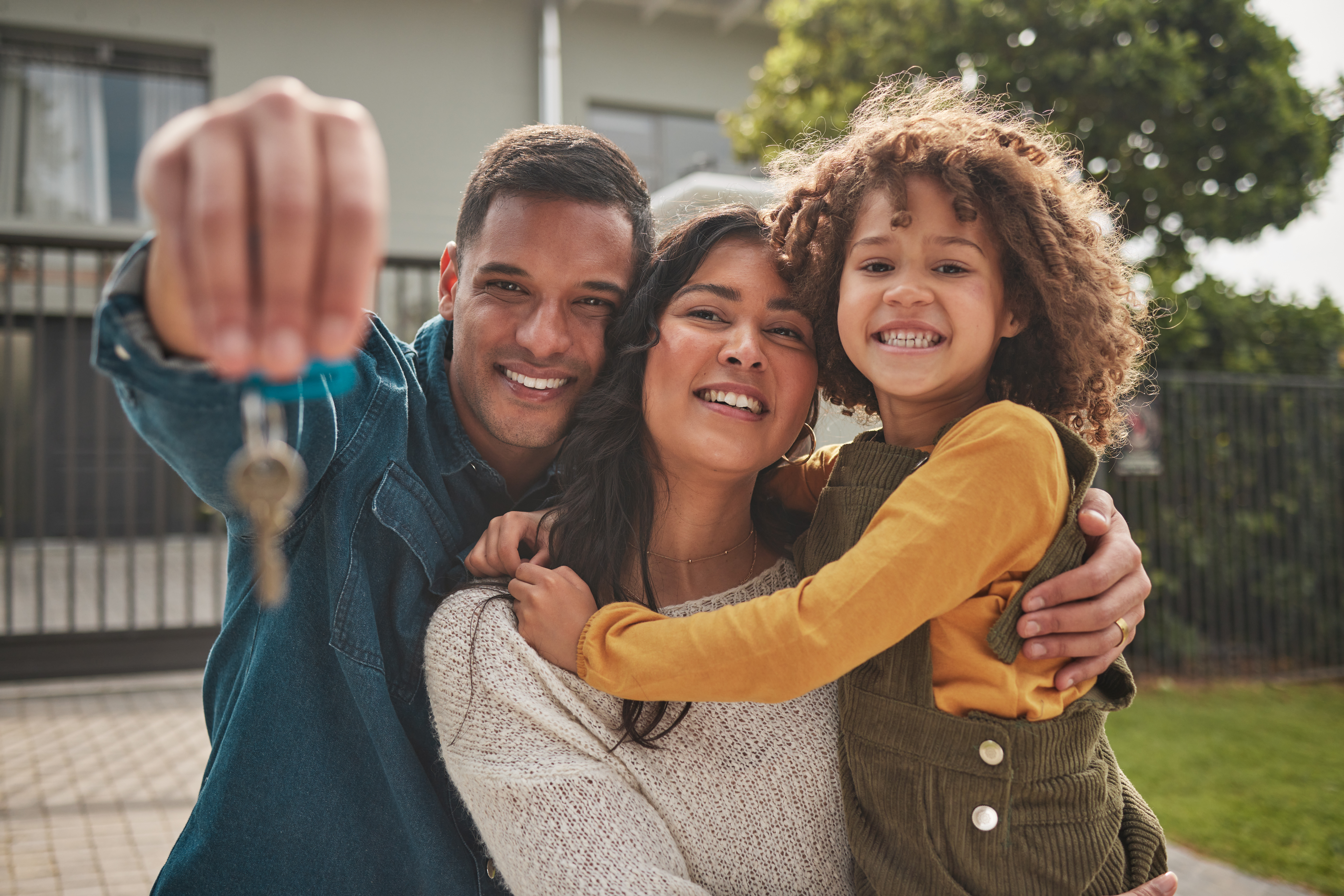 A multiracial family holds a key to their new house.