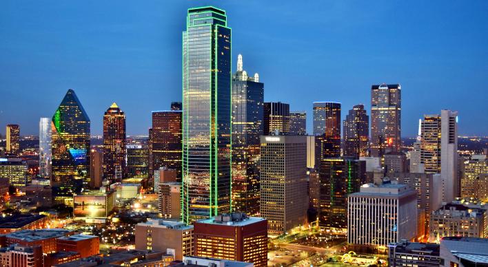 View of the Dallas skyline at dusk with building lights on.