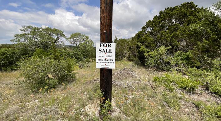 A for sale sign on a utility pole in the Texas Hill Country.