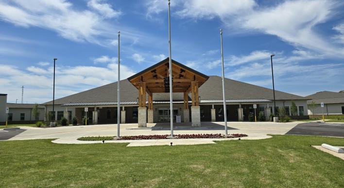 Front view of the Tuskegee Airmen Texas State Veterans Home with scattered clouds.